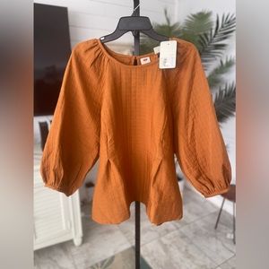 Levi’s burnt orange, puff sleeve top.